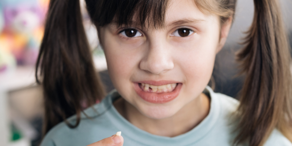 Dziecko z ukruszonym zębem mlecznym po upadku, trzymające się za usta &ndash; sytuacja wymagająca konsultacji stomatologicznej